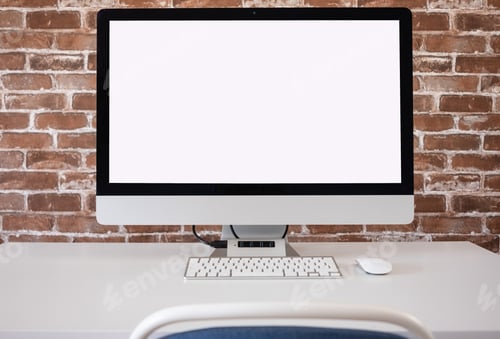 Preview: Blank white screen computer in minimal office room, copy space. Brick wall background