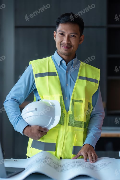 Preview: Asian engineer handsome man or architect looking forward with white safety helmet in construction