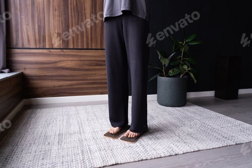 Preview: Unrecognizable young woman practicing standing on boards with nails.