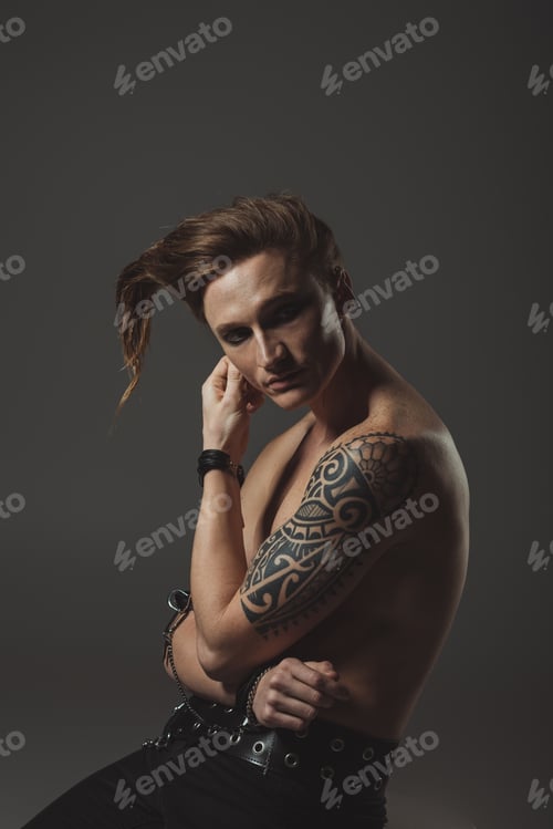 Preview: shirtless man with strange hairstyle and tattoo on hand, isolated on grey