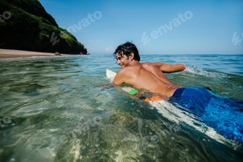 Preview: Male surfer in the ocean water with surf board