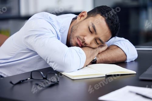 Preview: I just need a few minutes. Shot of an exhausted businessman having a quick nap on the desk at work.