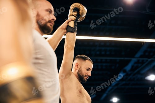 Preview: Judge lifting up a hand of a winning athlete