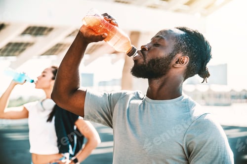 Preview: Fitness african athlete drinking energy drink outdoor