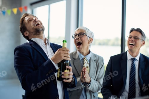 Preview: Cheerful business colleagues celebrating their success with a Champagne on office party,