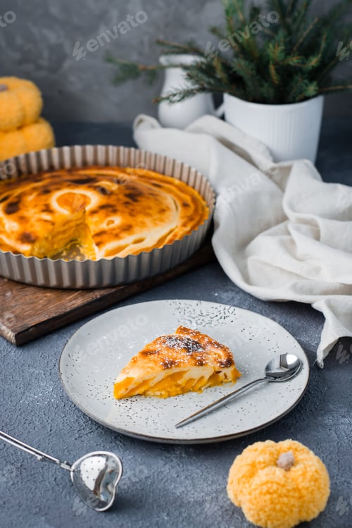 Preview: An appetizing piece of fresh sweet layered pumpkin pie in powdered sugar on a plate on the table.