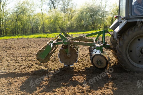 Preview: The tractor drives across the field and cultivates the land.