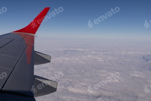 Preview: the wing of a flying aircraft against the background of clouds