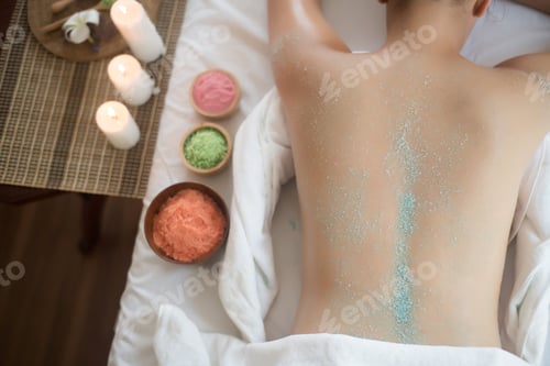 Preview: Beautiful woman getting a salt scrub beauty treatment in the health spa.