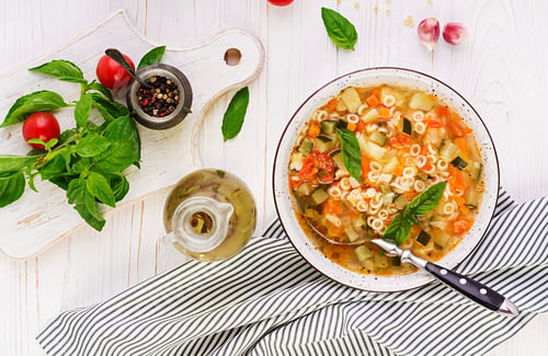 Preview: Minestrone, italian vegetable soup with pasta on white table. Vegan soup. Top view