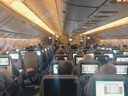 Preview: Interior of the plane with passengers in their seats watching the entertainment screens