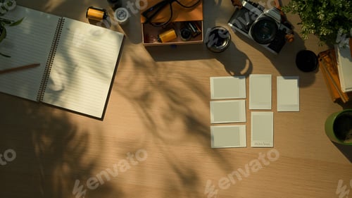 Preview: Creative workspace with vintage camera, notebook, and coffee cup in warm morning sunlight