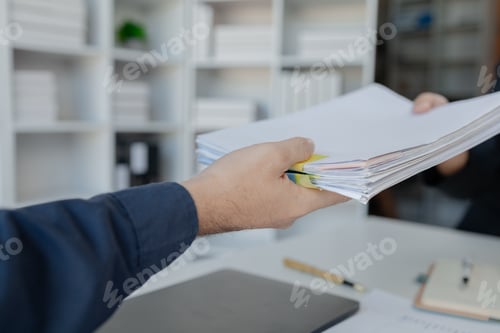 Preview: Businesspeople hands working in stacks of paper files for searching, business employee working in st