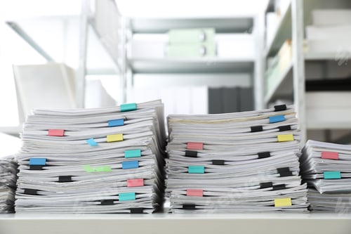 Preview: Stacks of documents with paper clips on office desk