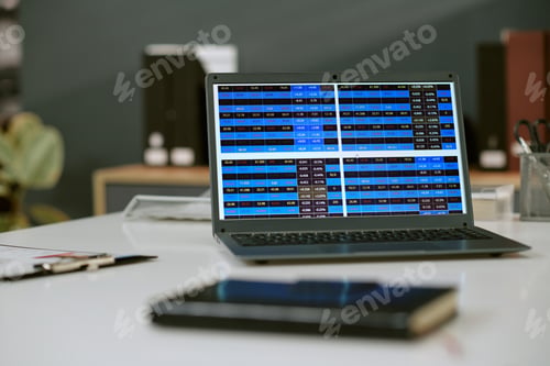 Preview: Laptop Displaying Financial Data Charts on Office Desk during Workday