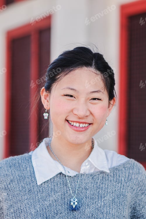 Preview: Vertical close up individual portrait of happy chinese young adult woman smiling and looking at