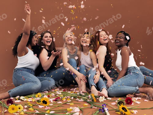Preview: Multi ethnic group of happy women sitting under falling petals