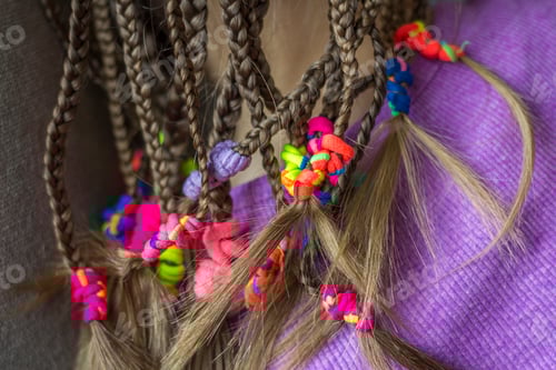 Preview: Close up of braid hair of little girl with colorful rubber bands