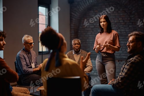 Preview: Young woman talking while attending mental health support group session at community center.