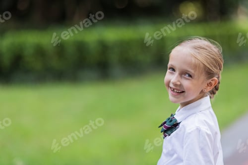 Preview: Schoolgirl back to school after vacations. Pupil in uniform smiling early morning outdoor