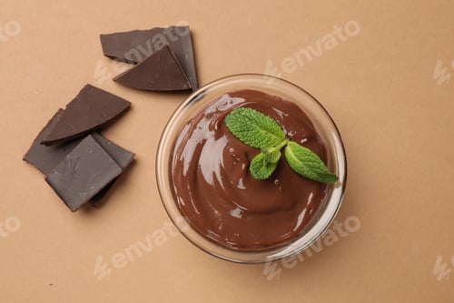 Preview: Delicious chocolate mousse in glass bowl on pale brown background, top view