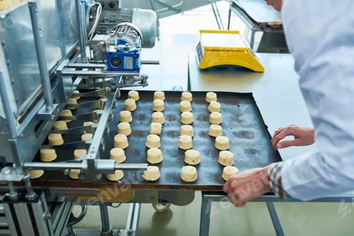 Preview: Factory worker operating confectionery machine
