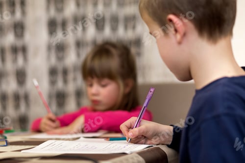 Preview: Two cute young children, boy and girl, brother and sister doing homework