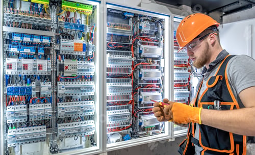 Preview: Male electrician working in electrical panel. Male electrician in overalls.