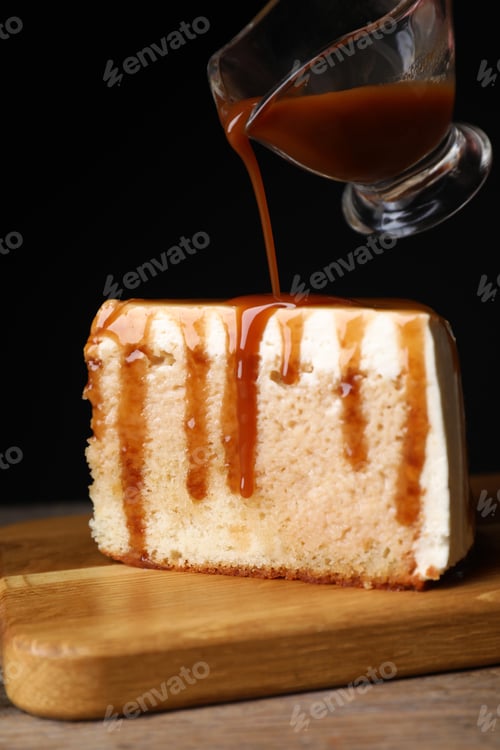 Preview: Pouring caramel sauce on slice of cake at wooden table