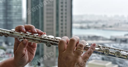 Preview: Music Woman playing flute on her high rise apartment building balcony with a panoramic view of the