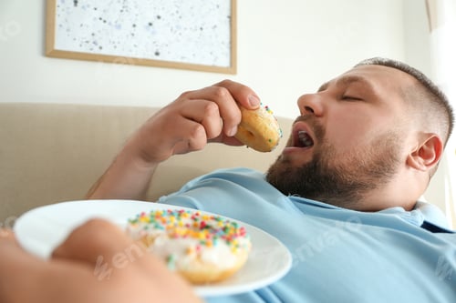 Preview: Lazy overweight man eating donuts at home, closeup