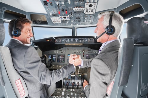 Preview: Germany, Bavaria, Munich, Businessmen piloting aeroplane from airplane cockpit