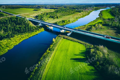 Preview: Aerial View of River, Bridge, and Lush Green Landscape Under a Clear Blue Sky