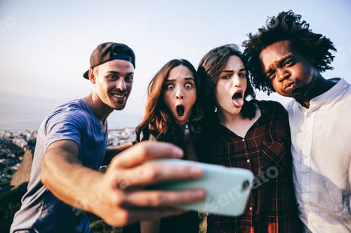 Preview: Friends pulling faces and taking selfie with smartphone