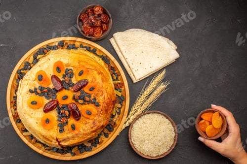 Preview: top view shakh plov delicious rice meal cooked inside round dough with raisins on grey desk rice