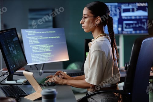 Preview: Middle Eastern Female Programmer Using Computer Writing Code at Workstation in Office