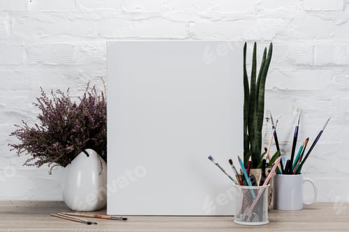 Preview: close up view of empty drawing easel and plants in flowerpots on table