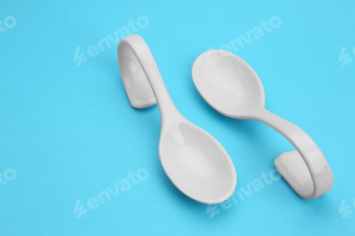 Preview: Clean empty ceramic appetizer spoons on blue background, space for text