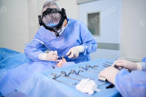 Preview: Specialist works with an assistant in an operating room