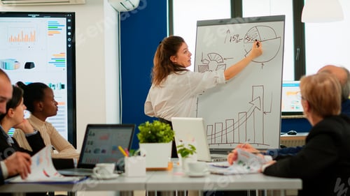 Preview: Focused team leader presenting marketing plan to interested multiracial coworkers