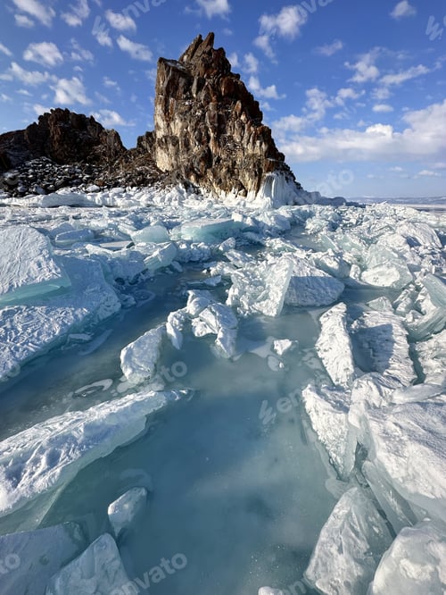 Preview: blue ice hummocks from the ice of Lake Baikal against the backdrop of Mount Shamanka