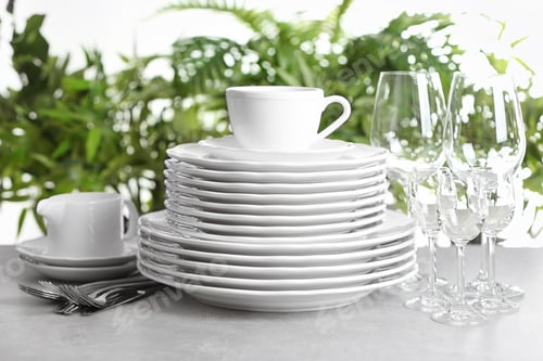 Preview: Set of clean dishes on blurred background