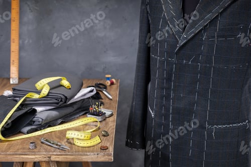 Preview: suit jacket on male tailor mannequin and sewing tools,