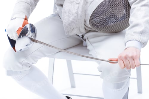 Preview: Cropped shot of professional fencer holding helmet and rapier while sitting on chair isolated on