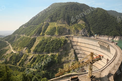 Preview: BATUMI, GEORGIA - AUGUST 13, 2022: Tower crane and hydroelectric power station in mountains