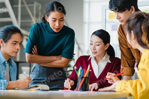 Preview: Asian businessmen and businesswomen meeting brainstorming ideas in small office.