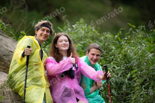 Preview: Group of friends in raincoats with backpacks on a hike in the forest, Prepare to hiking
