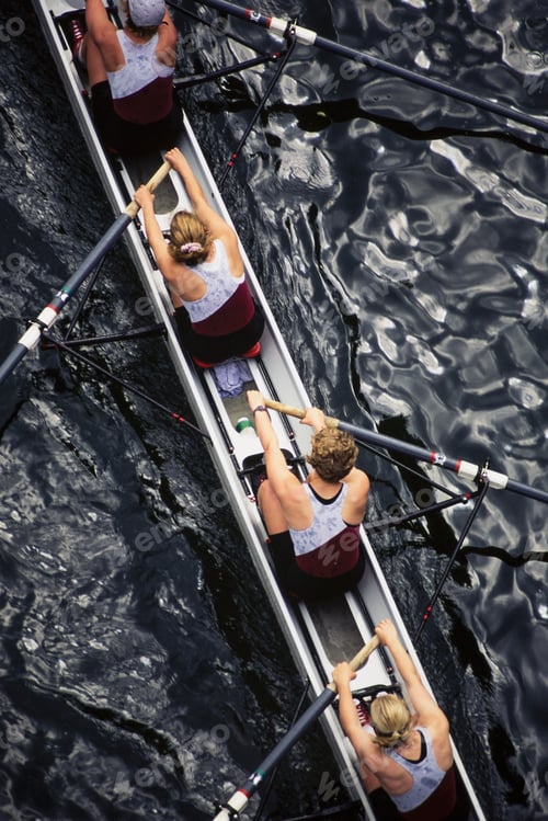 Preview: Overhead view of female crew racers rowing scull boat.
