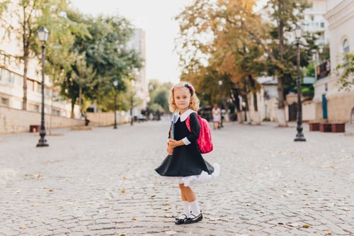 Preview: Schoolgirl holding textbooks on street