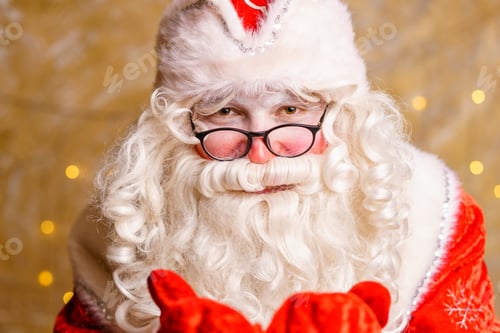 Preview: Portrait of santa claus in glasses looking at camera against background